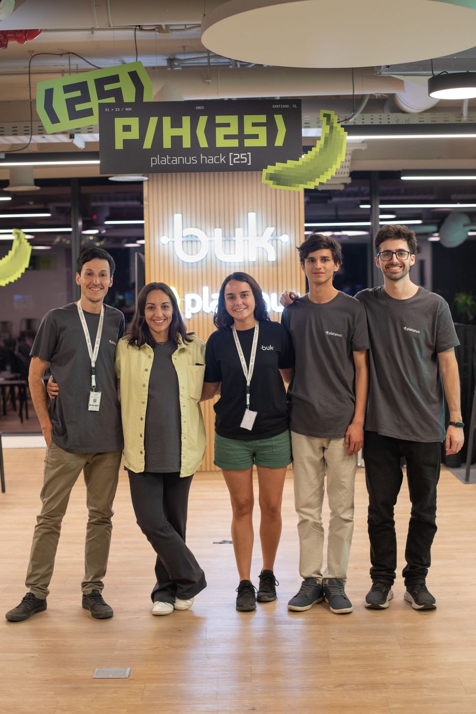 The Platanus Hack 25 staff under the P/H(25) sign